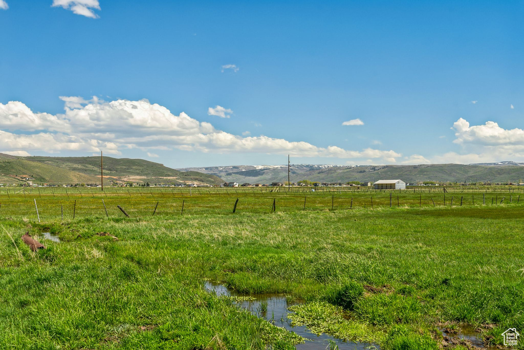 View of yard featuring a rural view, fence, and a mountain view