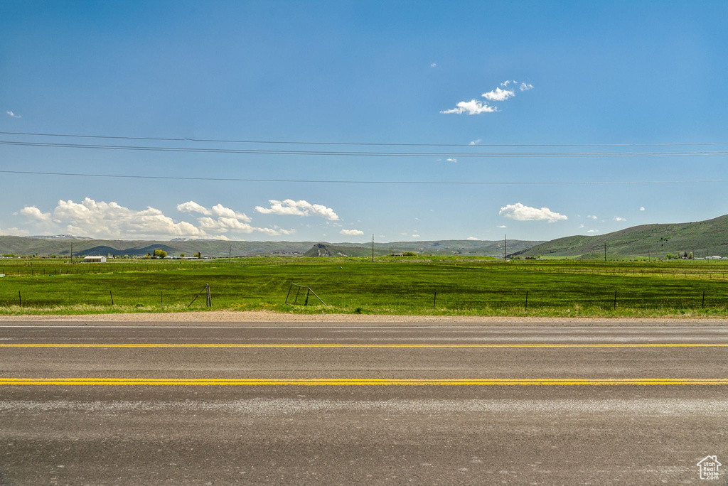 View of asphalt road featuring a view of countryside and a mountain view