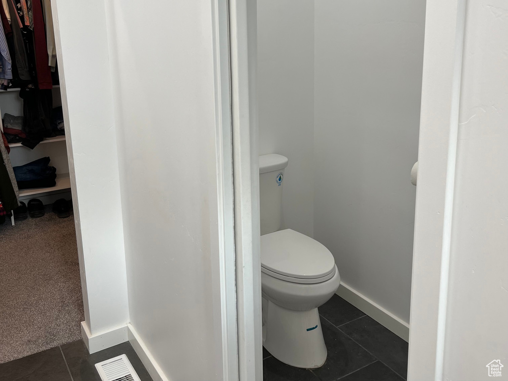 Bathroom with tile patterned floors, toilet, and baseboards