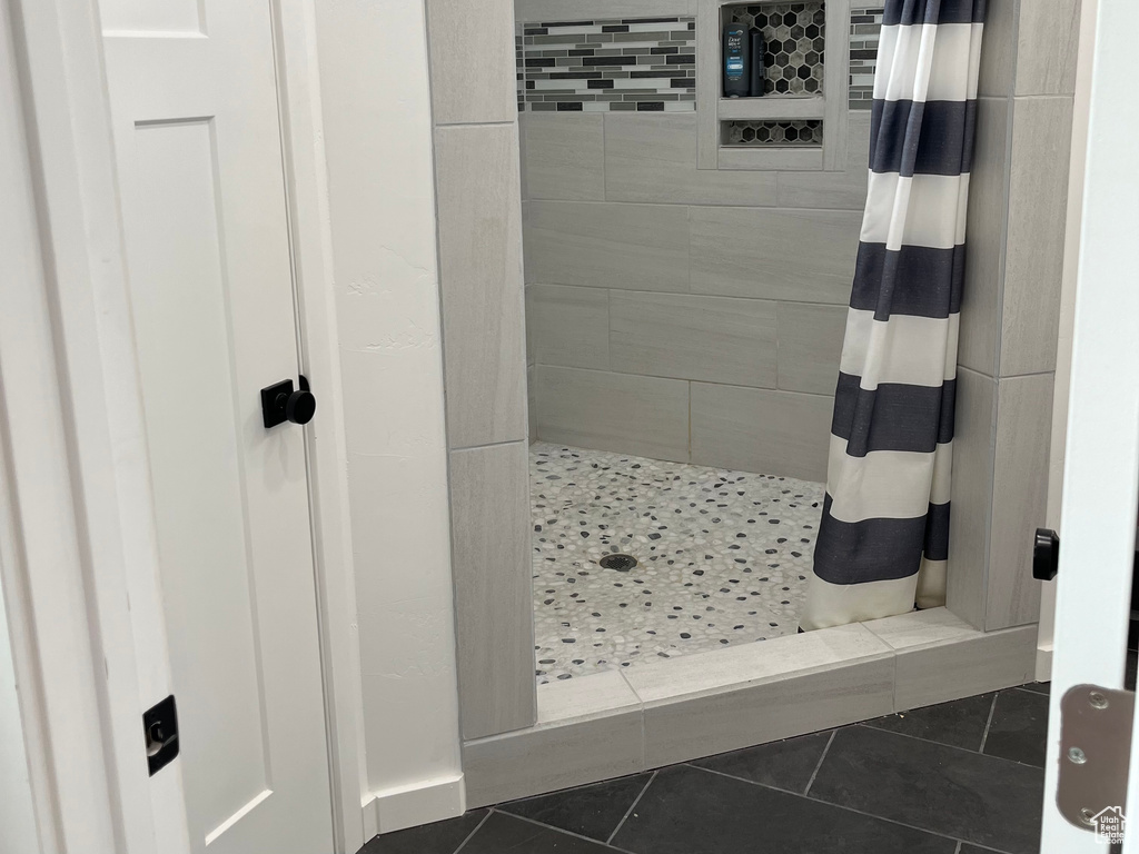 Bathroom with tiled shower and tile patterned flooring