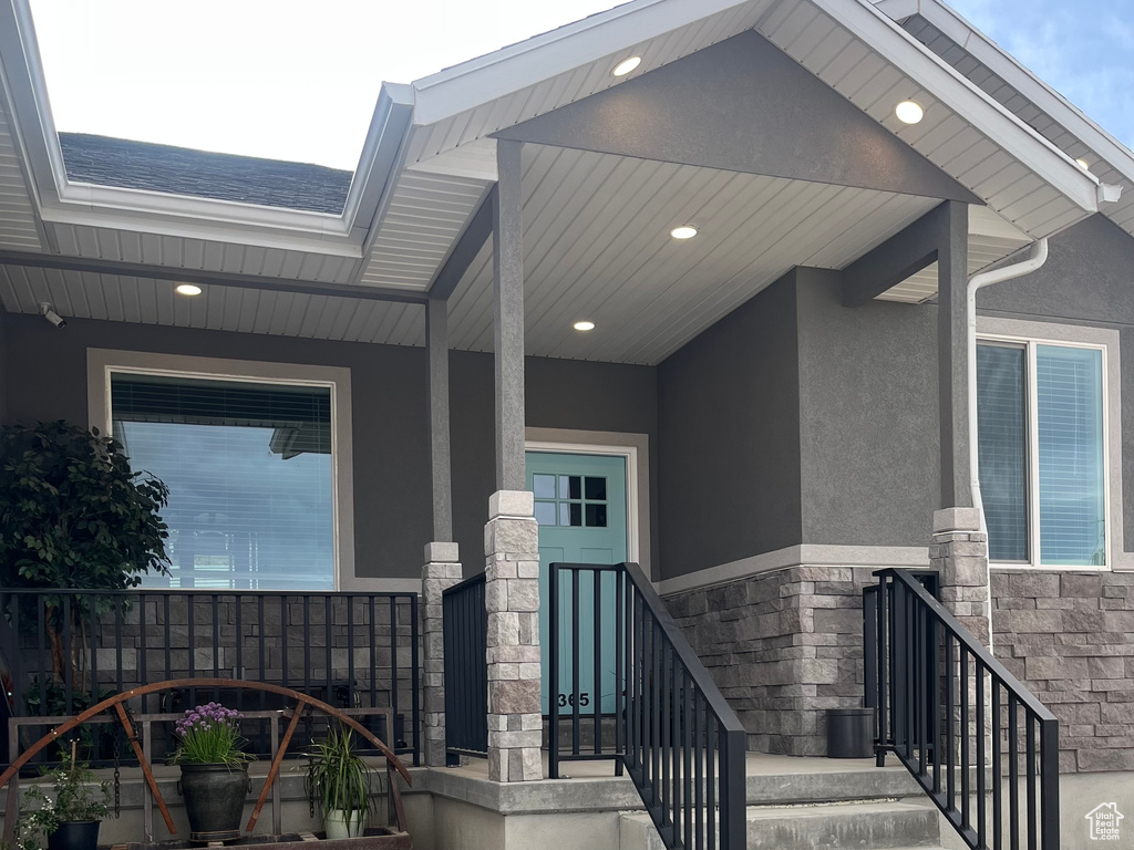 Doorway to property featuring stucco siding and stone siding