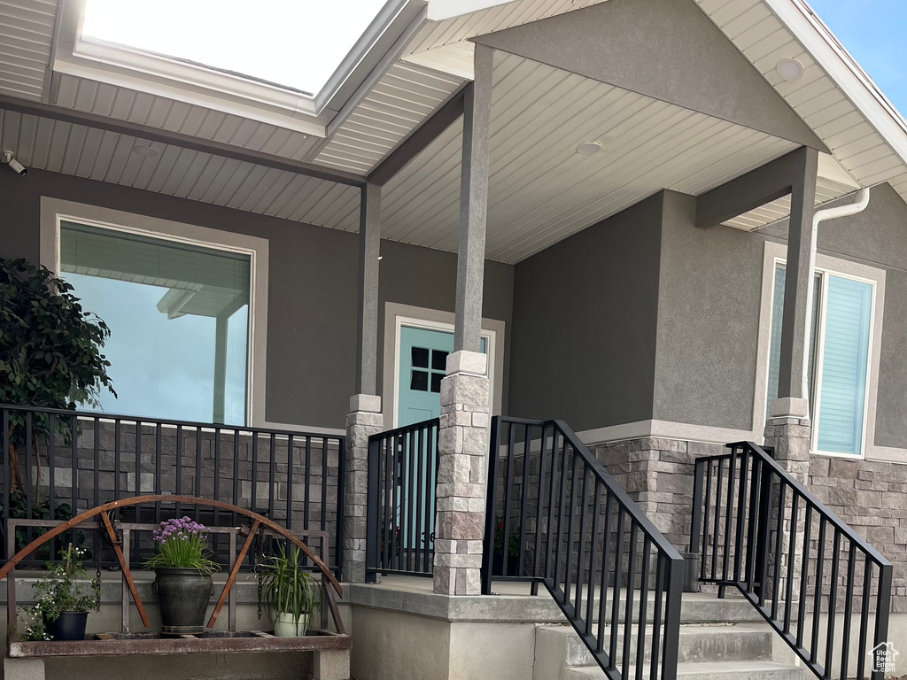 View of exterior entry with stucco siding and stone siding