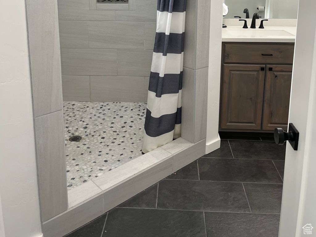 Bathroom featuring a shower stall, tile patterned floors, and vanity