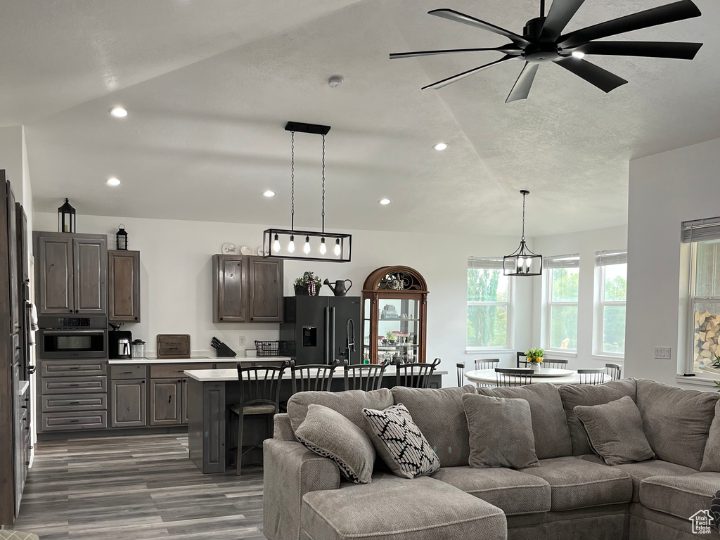 Living area featuring recessed lighting, wood finished floors, a ceiling fan, and a chandelier