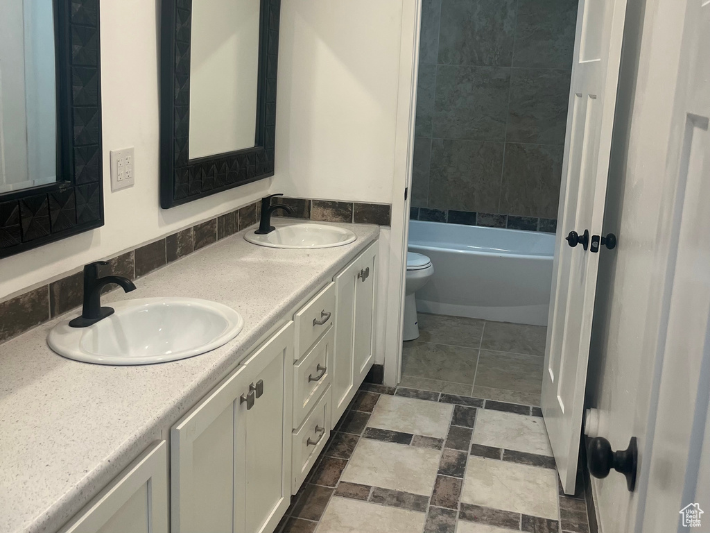 Bathroom featuring toilet and double vanity