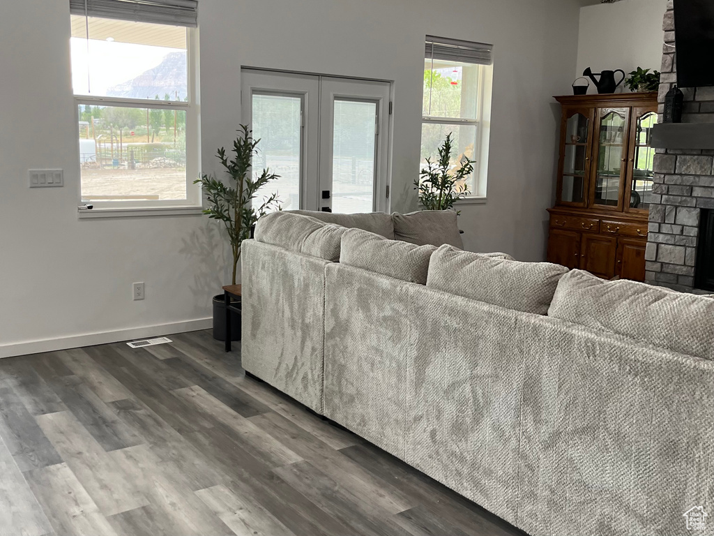 Living area with a fireplace, wood finished floors, plenty of natural light, and baseboards