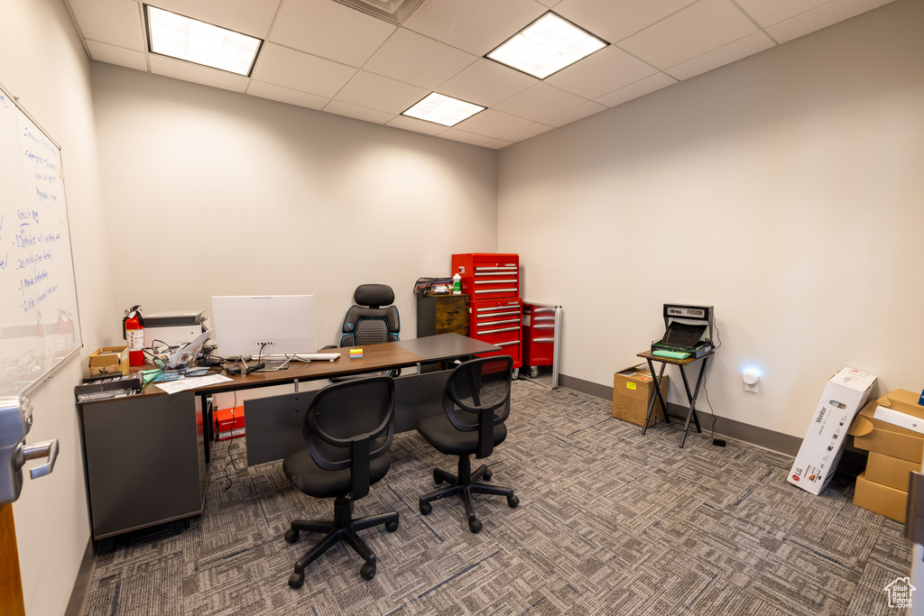 Carpeted home office featuring a drop ceiling and baseboards