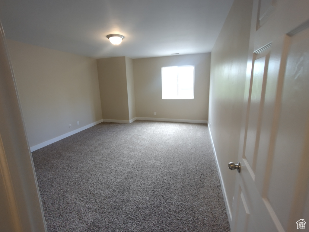 Carpeted empty room featuring baseboards