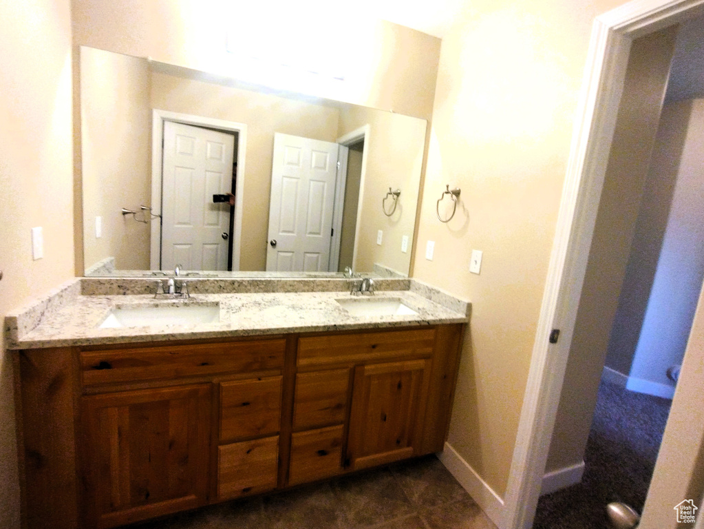 Bathroom featuring double vanity and baseboards