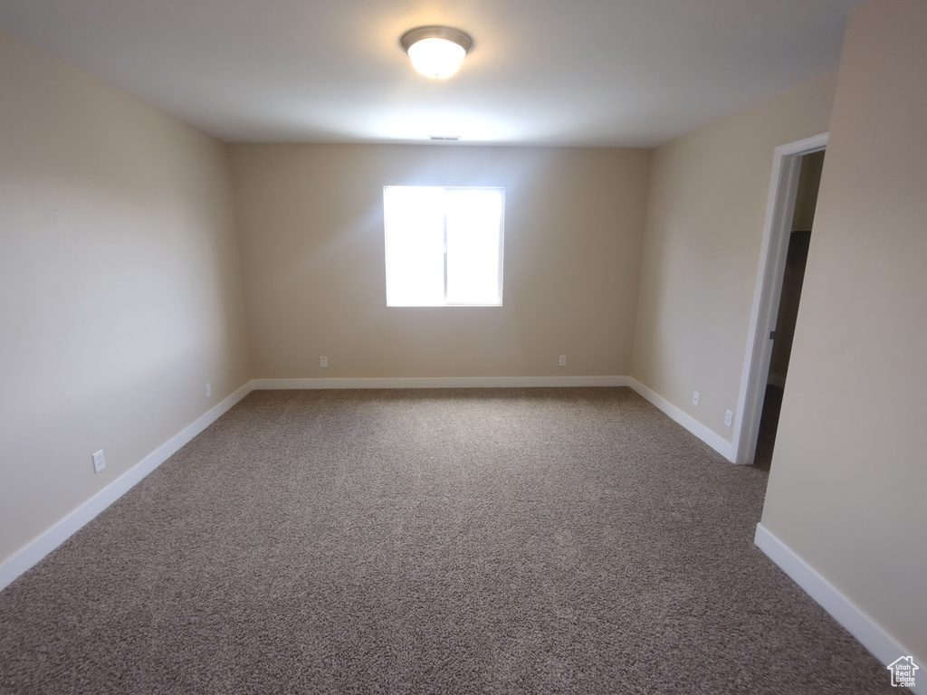 Spare room featuring carpet floors and baseboards