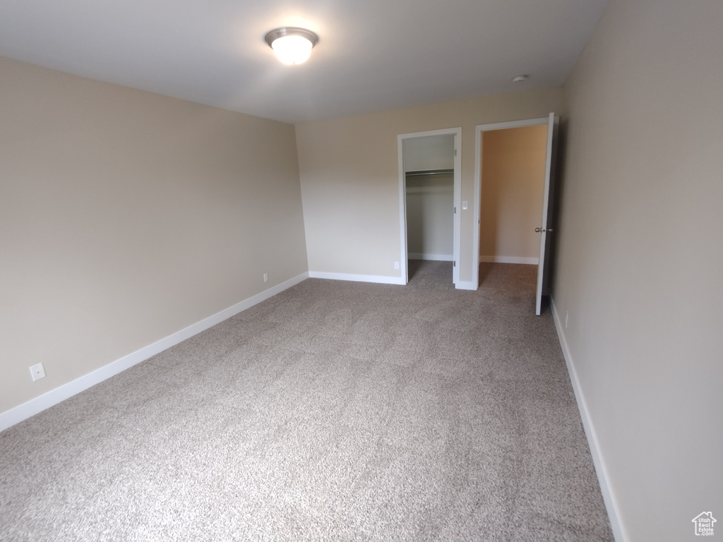 Unfurnished bedroom with carpet flooring, a closet, and baseboards