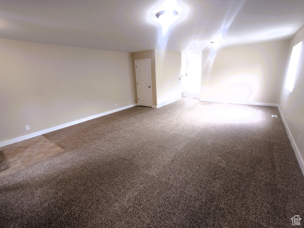 Carpeted empty room featuring baseboards