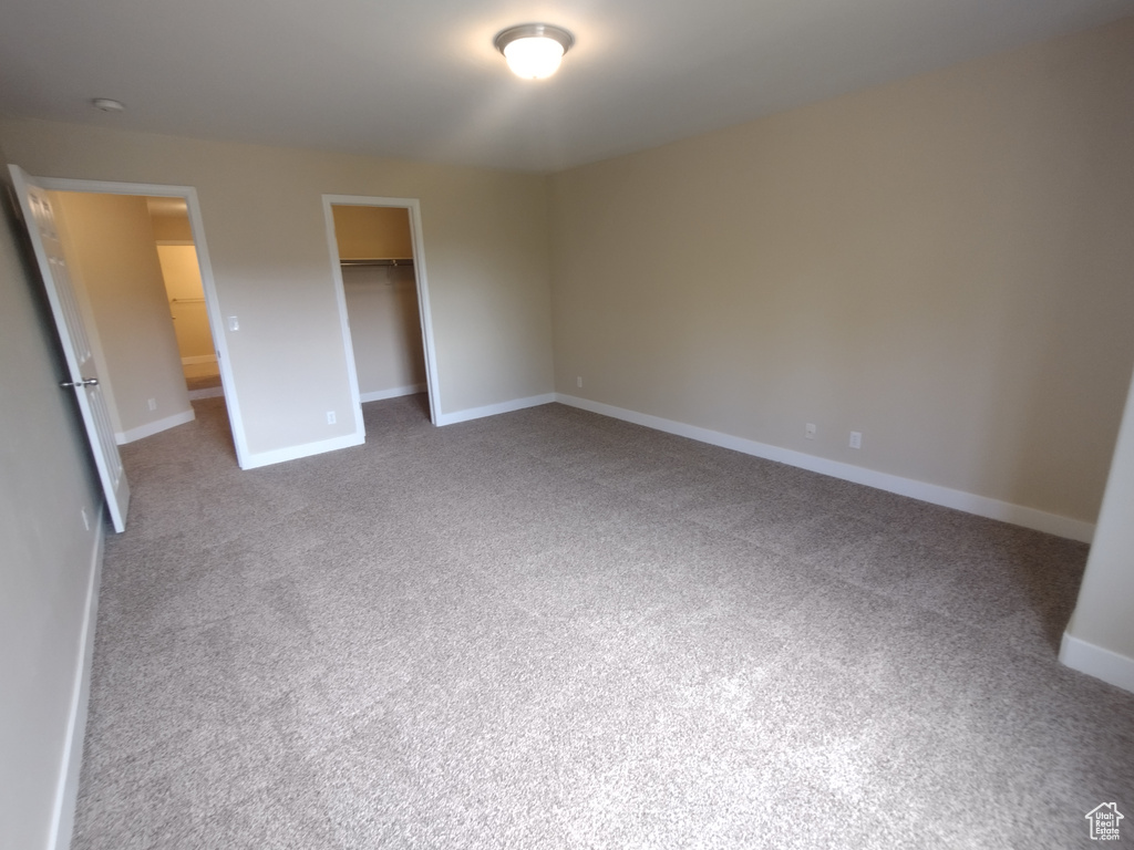 Unfurnished bedroom featuring carpet, baseboards, and a closet