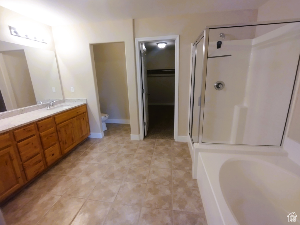 Full bathroom with a shower stall, toilet, vanity, and tile patterned flooring