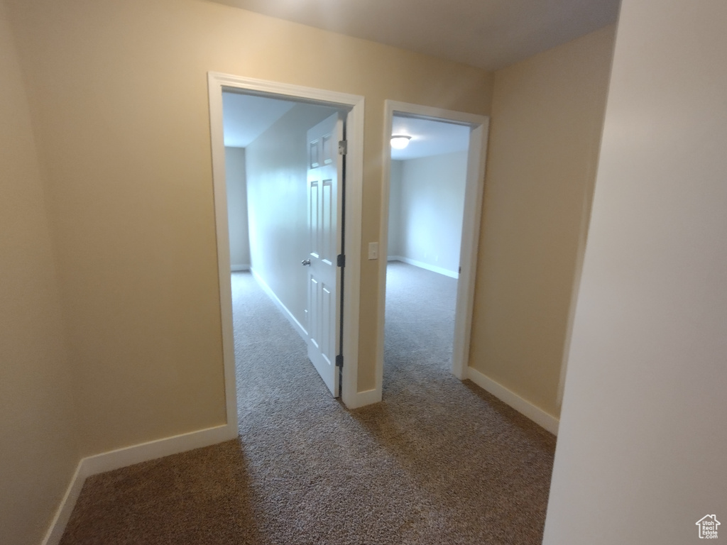 Hall featuring carpet flooring and baseboards