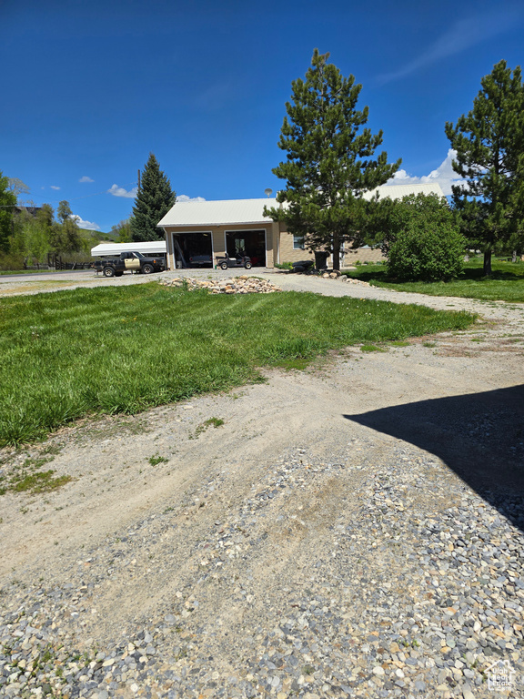View of front of home with driveway, a front lawn, and a garage