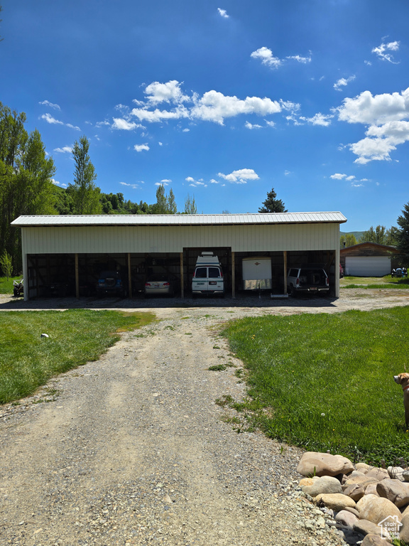 View of outbuilding featuring driveway and a detached carport
