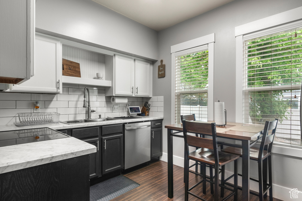 Kitchen featuring dishwasher, a sink, open shelves, and healthy amount of natural light