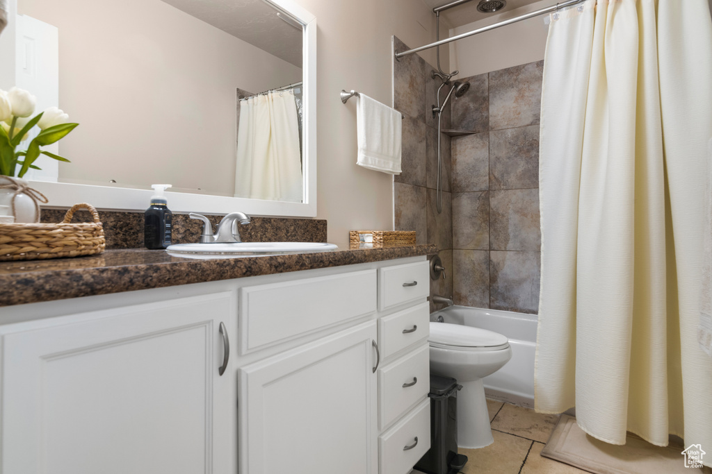 Full bathroom featuring tile patterned floors, vanity, toilet, and shower / bath combination with curtain