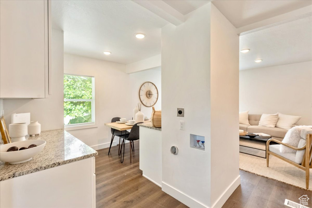Corridor with wood finished floors, baseboards, and recessed lighting