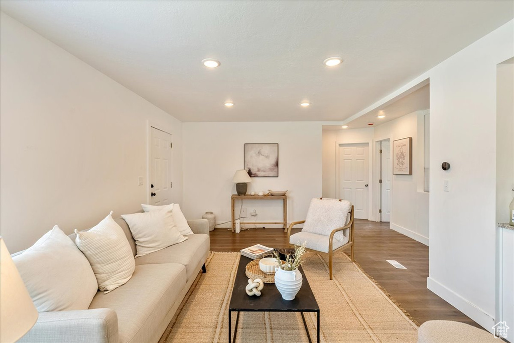 Living room featuring baseboards, wood finished floors, and recessed lighting