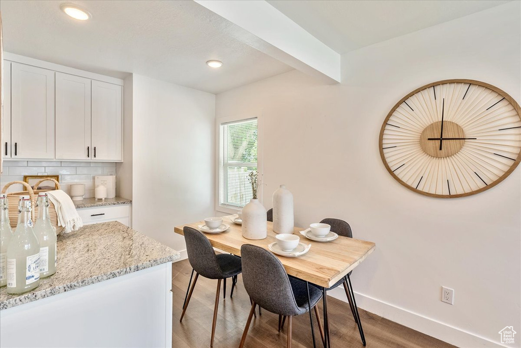 Dining room with baseboards, light wood finished floors, and recessed lighting