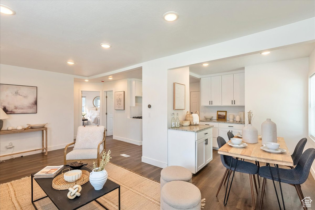 Living area featuring dark wood-style flooring, baseboards, and recessed lighting