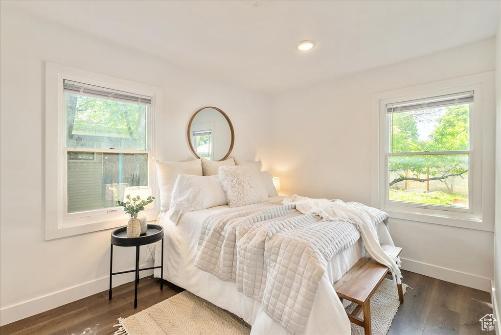 Bedroom with baseboards and dark wood-style flooring