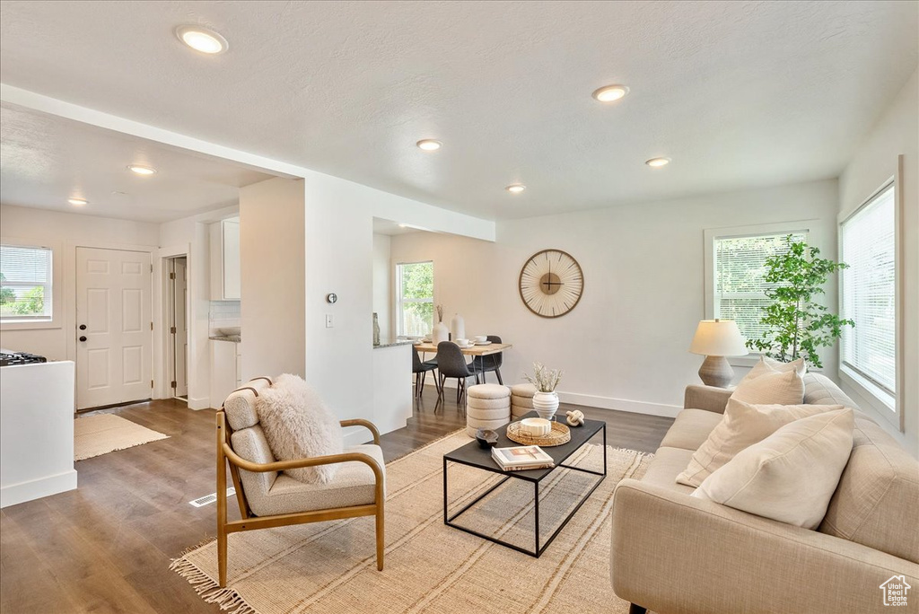 Living area with wood finished floors, recessed lighting, and baseboards