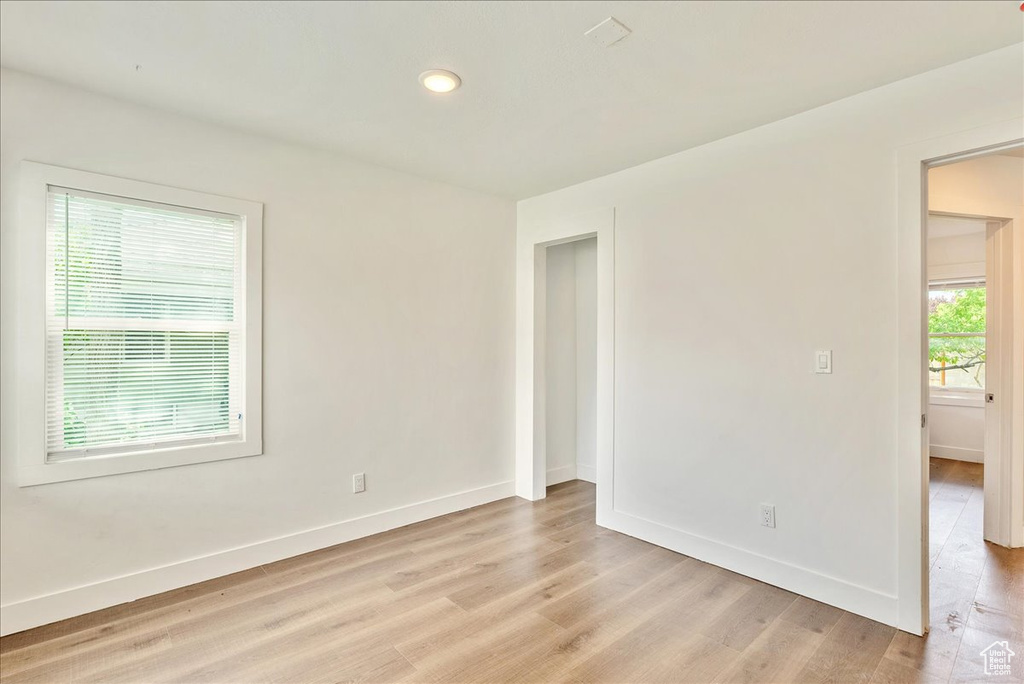Spare room featuring baseboards, light wood-type flooring, and recessed lighting