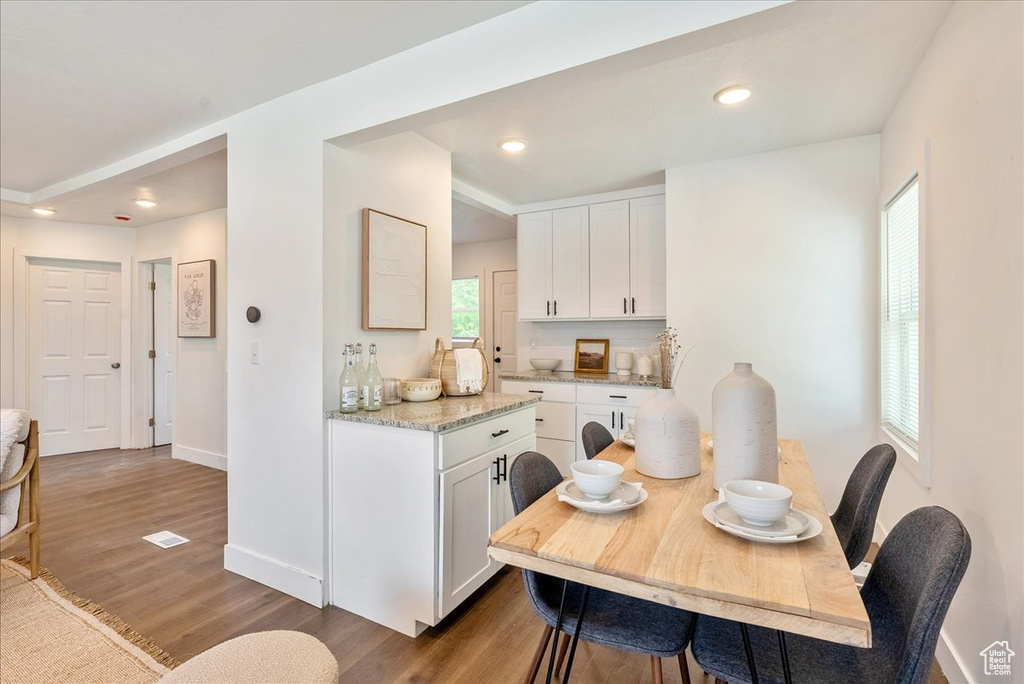 Dining room with wood finished floors, baseboards, and recessed lighting