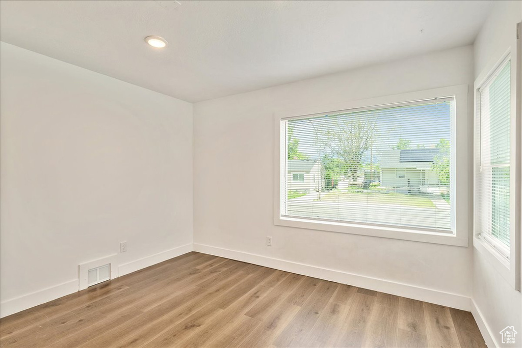 Spare room with light wood-style flooring, baseboards, and recessed lighting