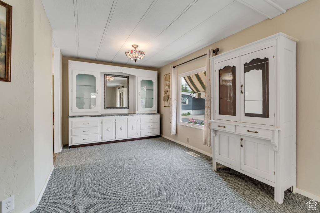 Unfurnished bedroom with carpet flooring and baseboards