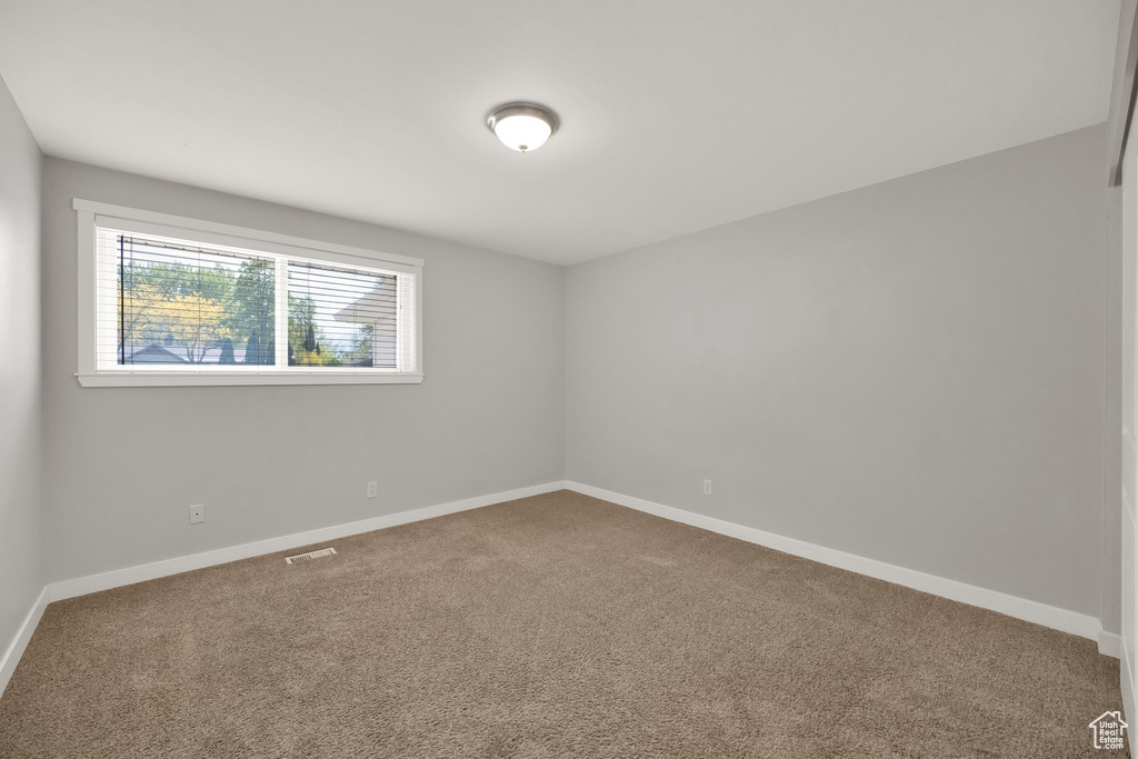 Carpeted spare room with baseboards
