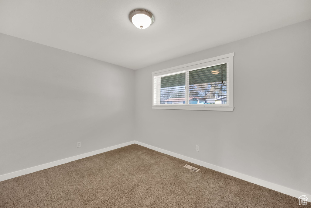 Carpeted empty room featuring baseboards