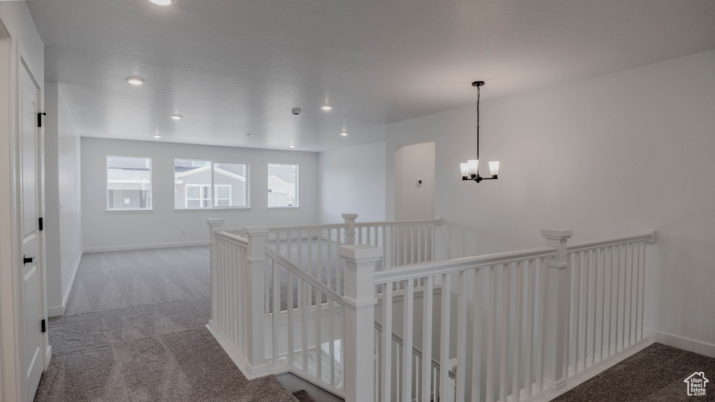 Hallway with an upstairs landing, carpet floors, a chandelier, and recessed lighting