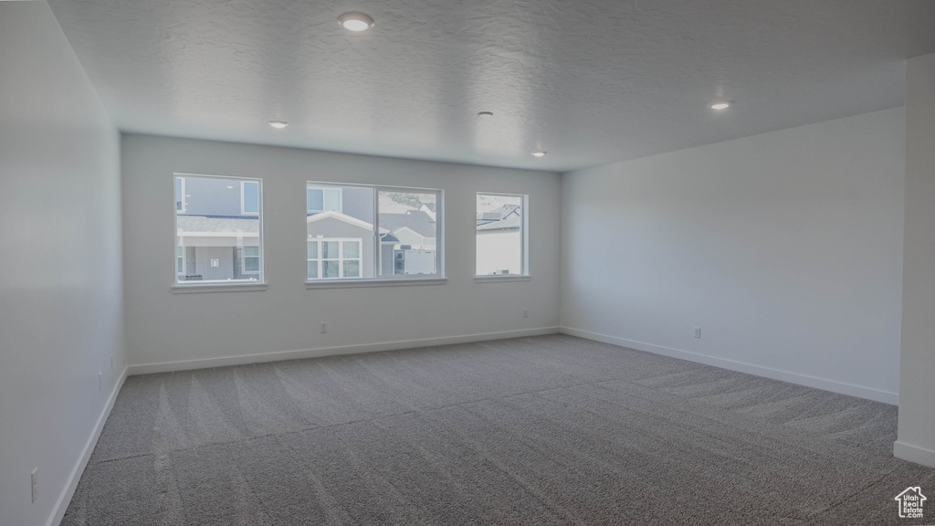 Carpeted spare room featuring recessed lighting and a textured ceiling