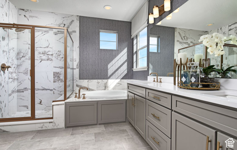 Bathroom featuring a marble finish shower, a bath, double vanity, and recessed lighting