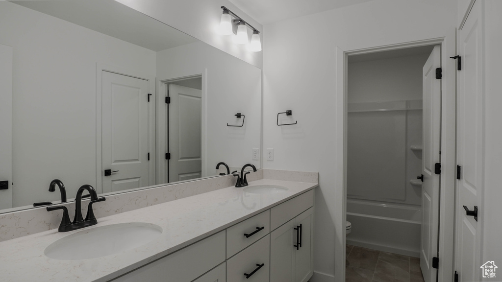 Full bathroom featuring double vanity and tub / shower combination