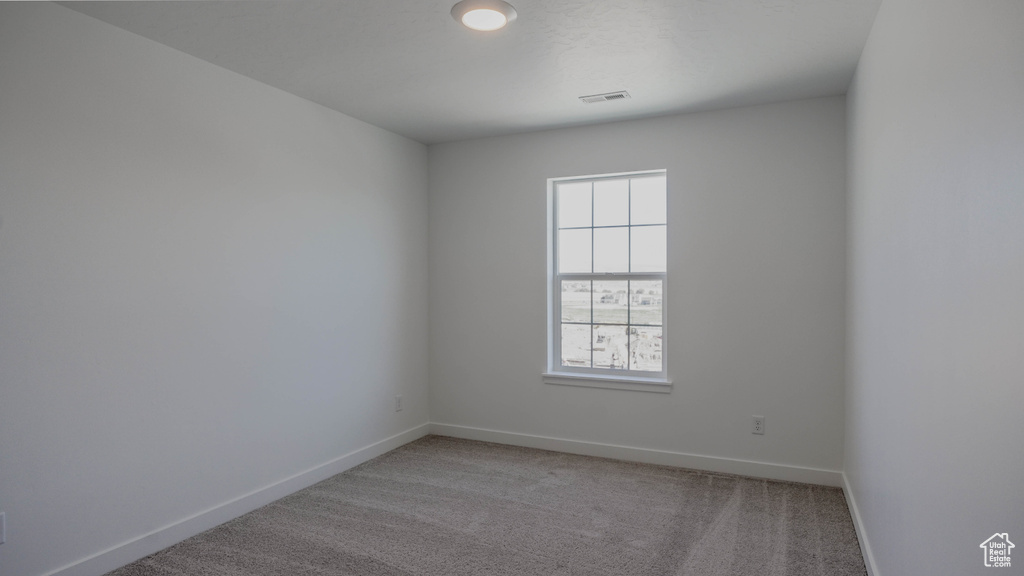 Carpeted empty room featuring baseboards
