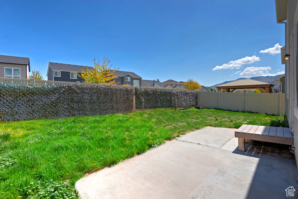 View of yard with a patio area, a residential view, a gazebo, and a fenced backyard