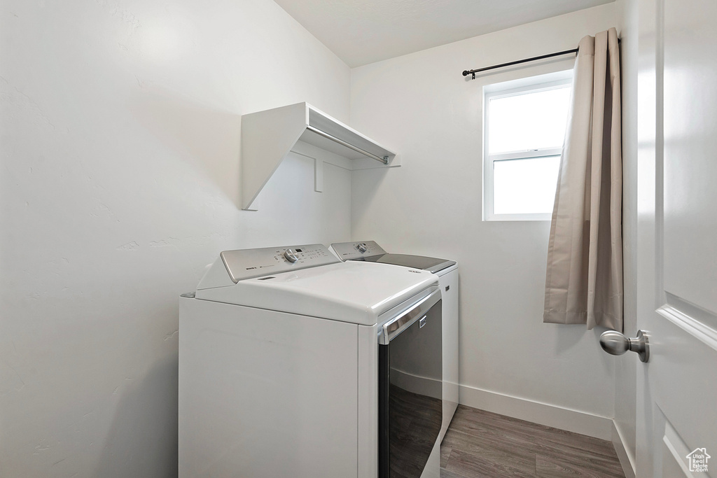 Laundry room featuring baseboards, laundry area, independent washer and dryer, and wood finished floors