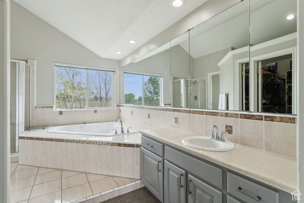 Bathroom with vaulted ceiling, a shower stall, vanity, recessed lighting, and a bath