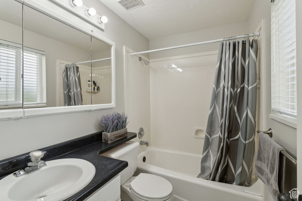 Full bath featuring shower / bath combo, vanity, and toilet