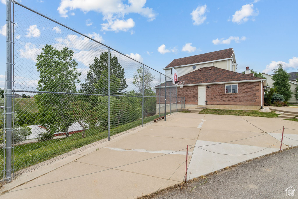 View of basketball court featuring basketball hoop and fence