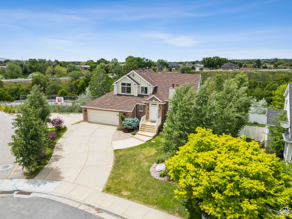 View of front of home with driveway, brick siding, and an attached garage