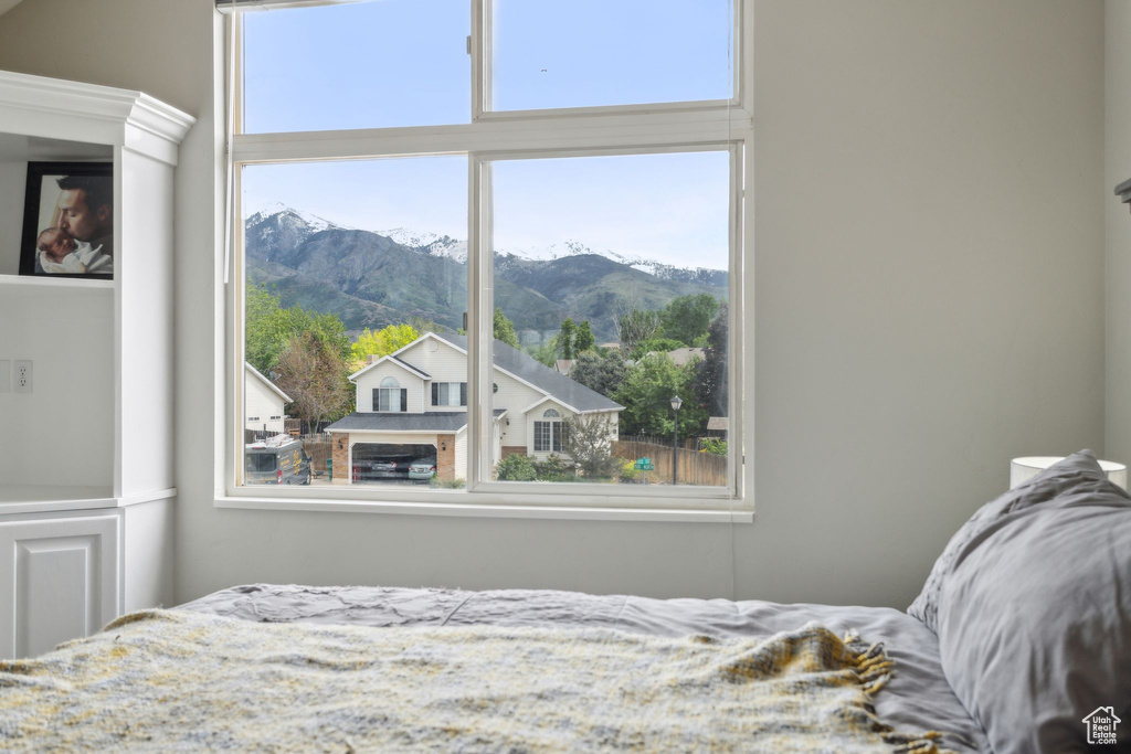Bedroom featuring a mountain view and multiple windows