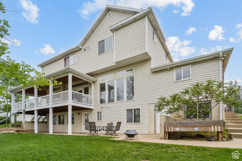 Rear view of property featuring stairs, a yard, and a patio