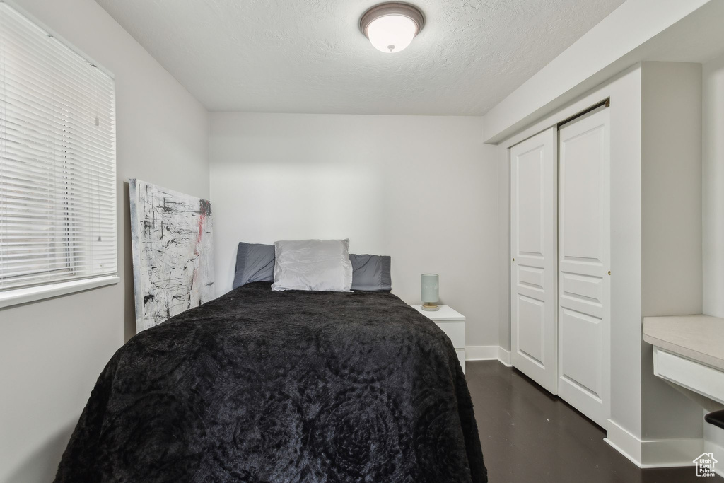 Bedroom featuring concrete flooring, a closet, and a textured ceiling