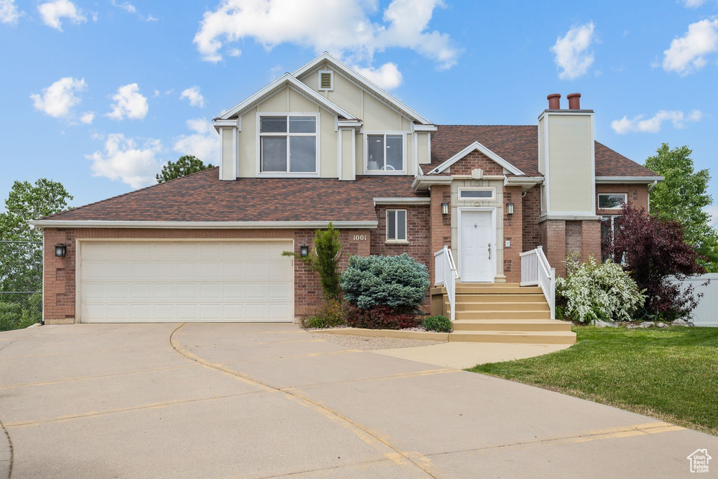 View of front of house featuring concrete driveway, roof with shingles, a chimney, and brick siding